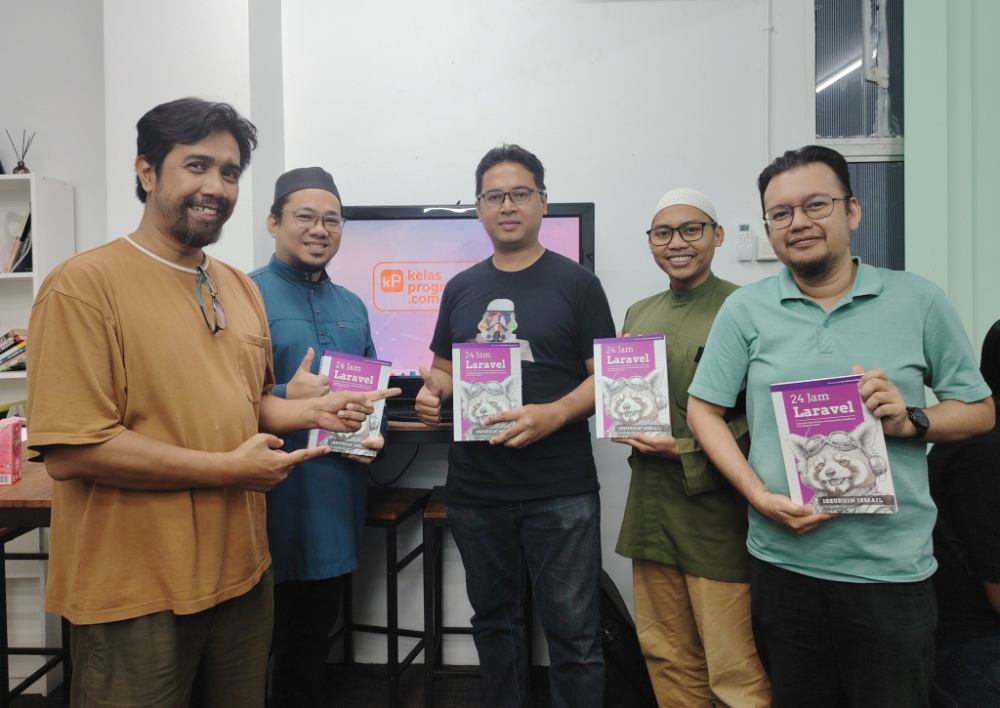Peserta kelas memegang buku 24 Jam Laravel